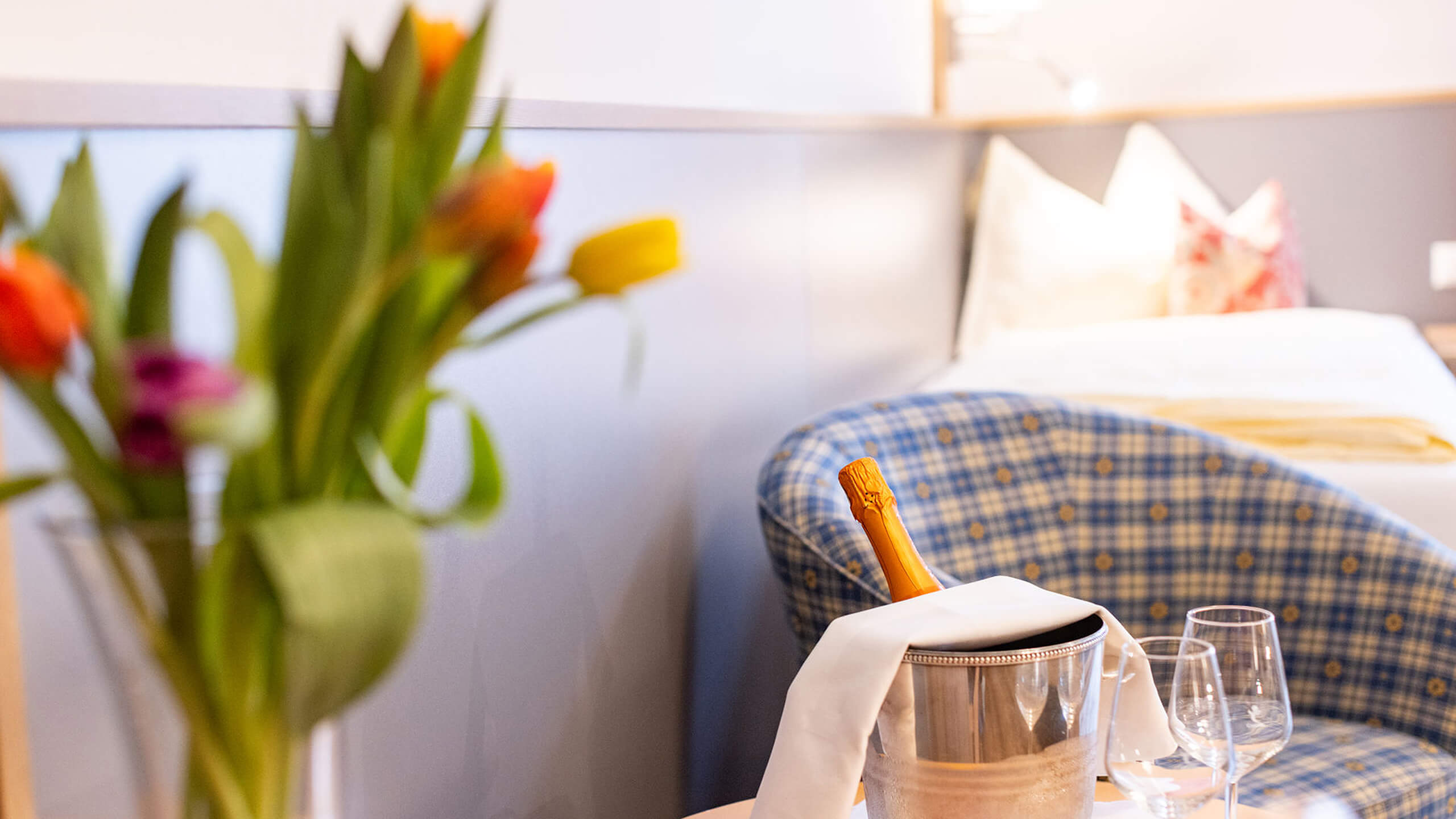 Zwei Gläser Wein mit Weinflasche und Blumen