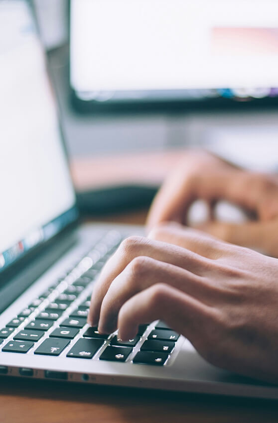 Person schreibt auf Laptop