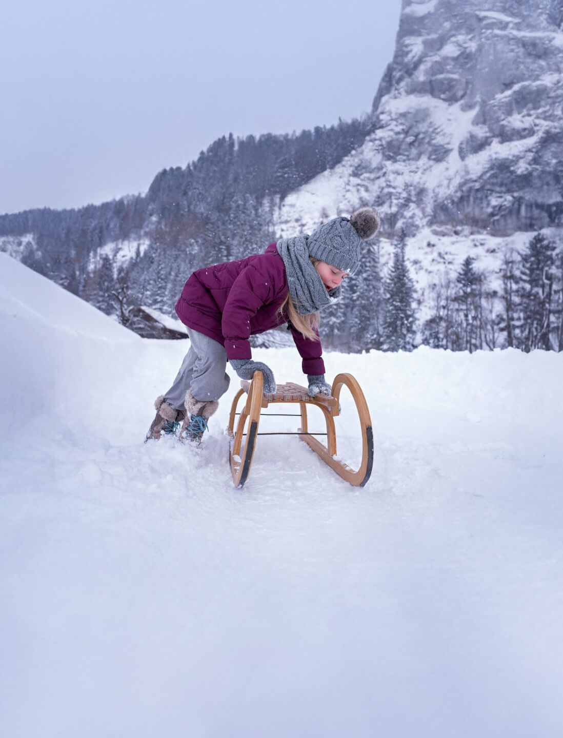 Kind steigt auf Rodel