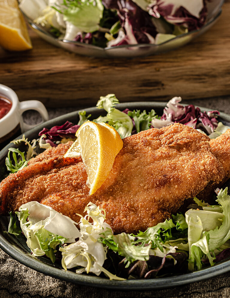 Schnitzel auf Salat mit Zitronen